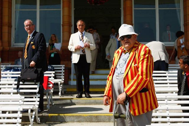 MCC members look on from Lord's pavilion, resplendent in the
club's egg-and-bacon stripes