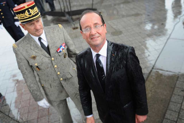 Raining President: A sodden François Holland attends a ceremony at Paris's Tomb of the Unknown Soldier, hours after his inauguration