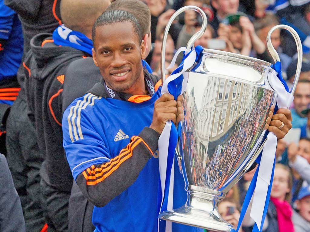 Chelsea football club player Didier Drogba holds the Champions League and FA Cup