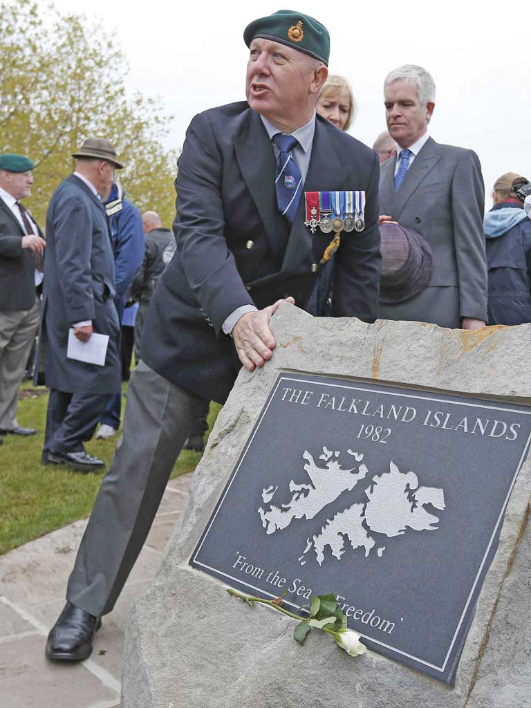 A veteran touches a plaque following a dedication service for the new Falklands Memorial at the National Memorial Arboretum in Alrewas