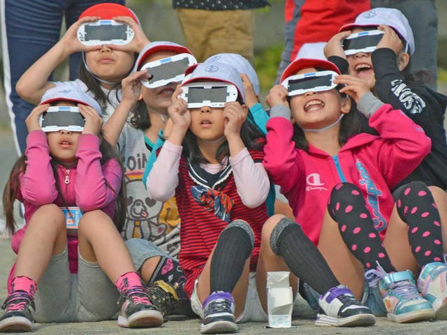 Japanese school children use specially designed eye glasses to see the annular eclipse