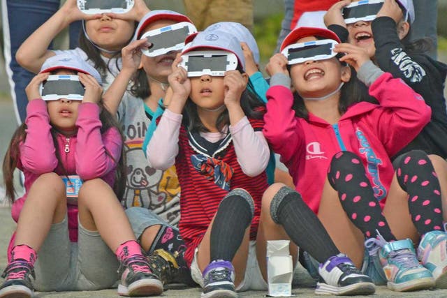 Japanese school children use specially designed eye glasses to see the annular eclipse