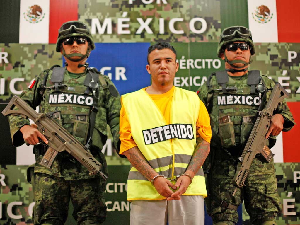 Soldiers escort Daniel Elizondo, a Zetas drug cartel leader, who is said to have ordered the massacre of 49 people
near Monterrey in Mexico this month