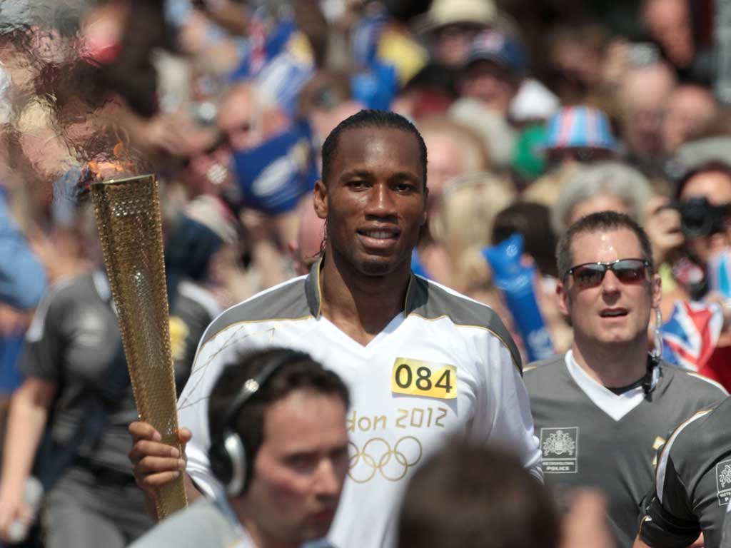 Drogba, who announced yesterday he was quitting Chelsea, waved at supporters as he jogged through the town centre with his torch