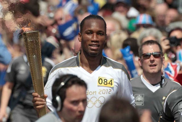 Drogba, who announced yesterday he was quitting Chelsea, waved at supporters as he jogged through the town centre with his torch