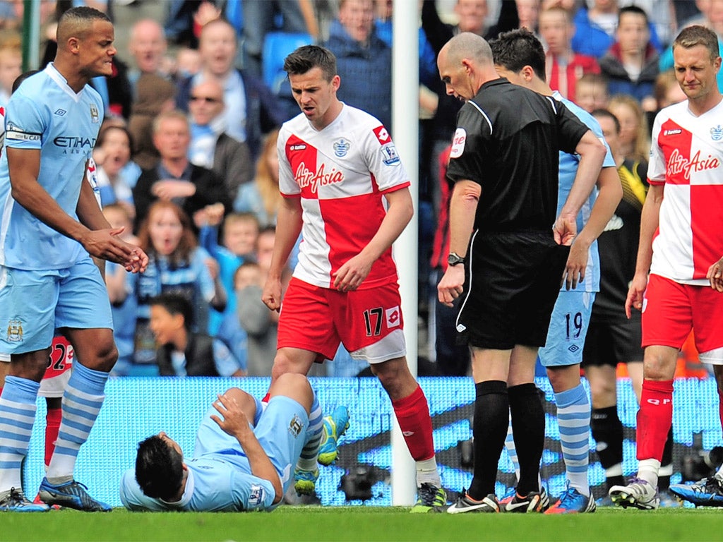 Joey Barton stands over Manchester City's Sergio Aguero, after being sent off by Mike Dean