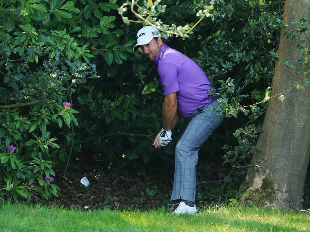 Graeme McDowell plays his shot out of the bushes on 18