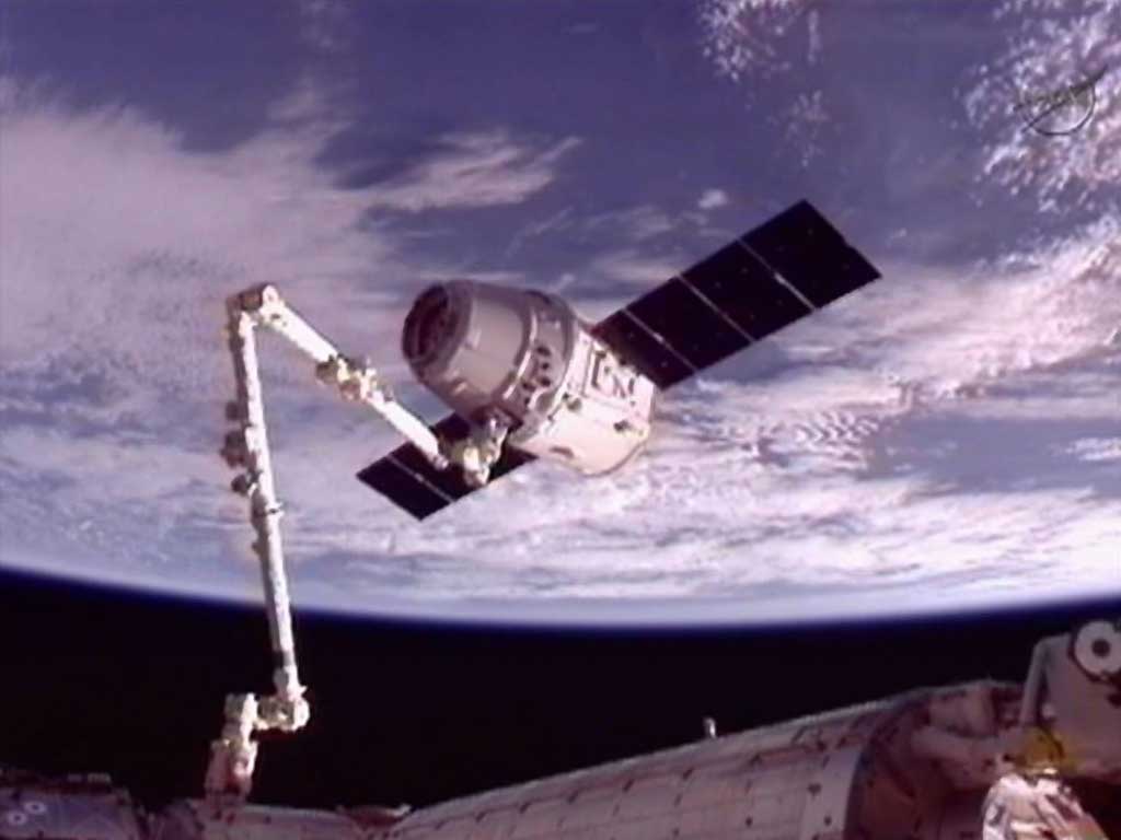 The SpaceX Dragon commercial cargo craft is moved into position for docking with the International Space Station using the station's Canadarm2