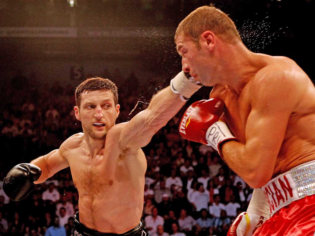 Carl Froch punches Lucian Bute during their IBF super-middleweight title bout