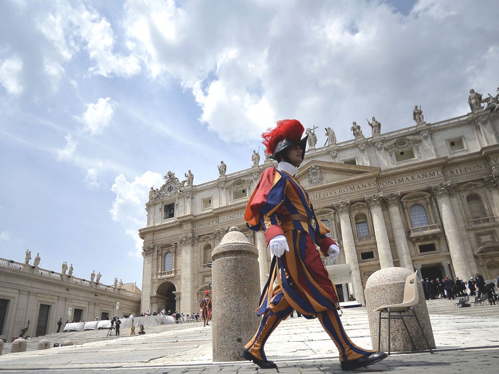 A guard walks past St. Peter's Bascilica