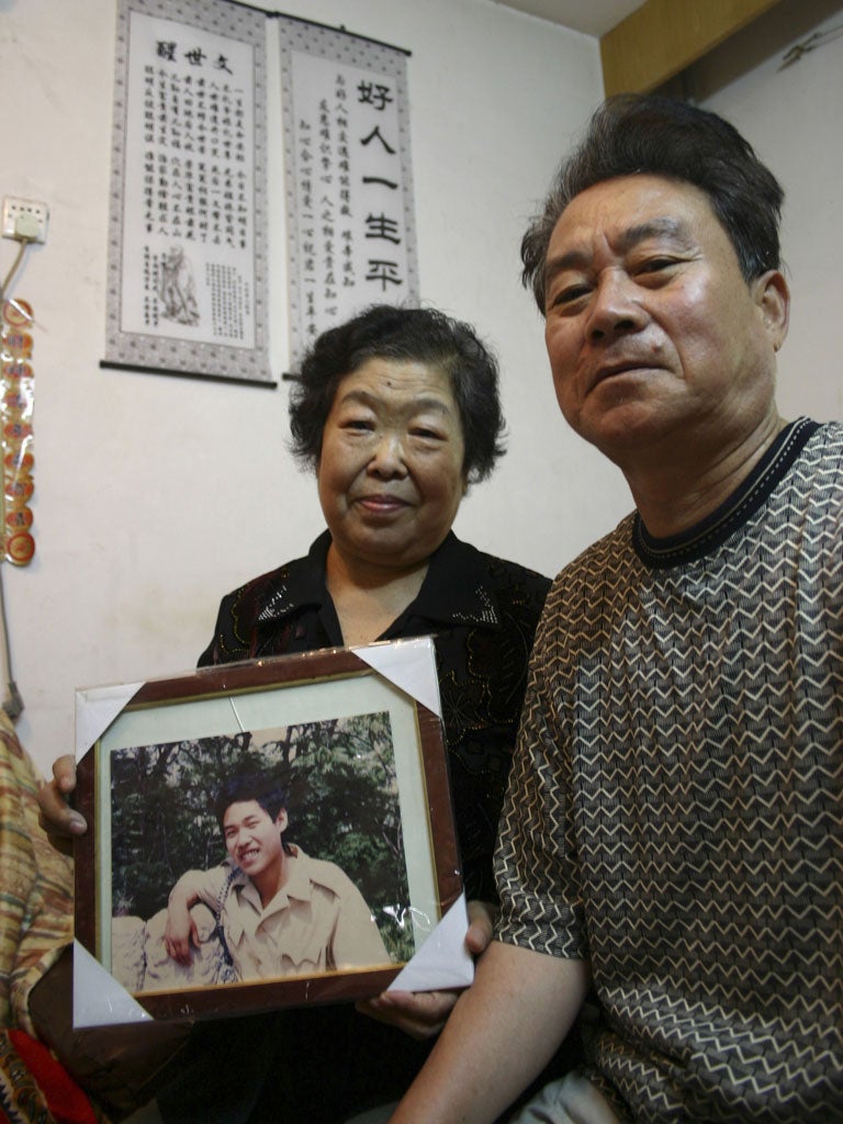 Ya Weilin and his wife, Zhang Zhengxia, with a photo of Ya Aiguo