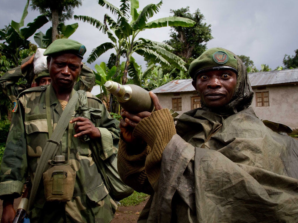 A Congolese soldier displays a mortar round after returning from the front line