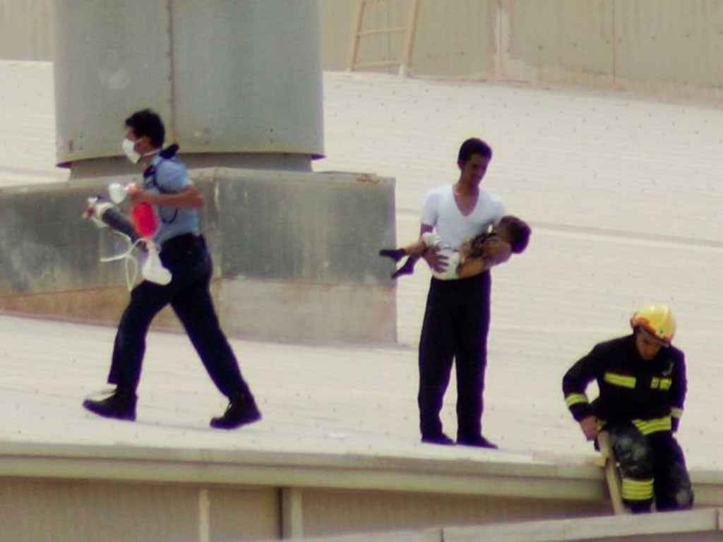 A rescuer carries a child to safety after the fire in Doha