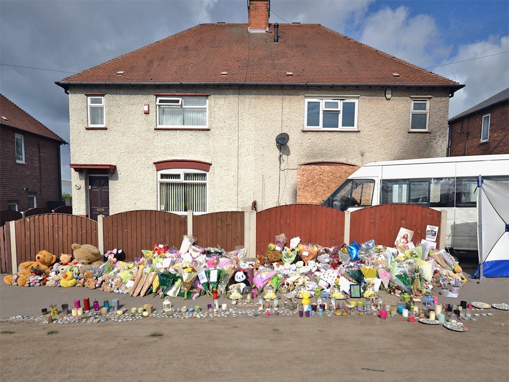Floral tributes adorn the pavement outside the house in Allenton, Derby