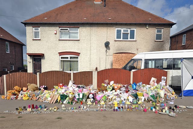 Floral tributes adorn the pavement outside the house in Allenton, Derby