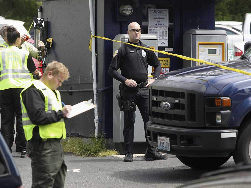 Crime scene investigators continue their investigation in the Seattle car park where a gunman killed a woman