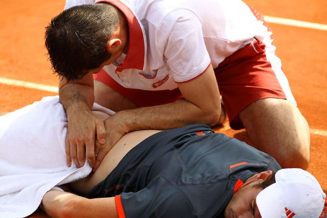 Murray receives assistance for a back problem during his match against Jarkko Nieminen
