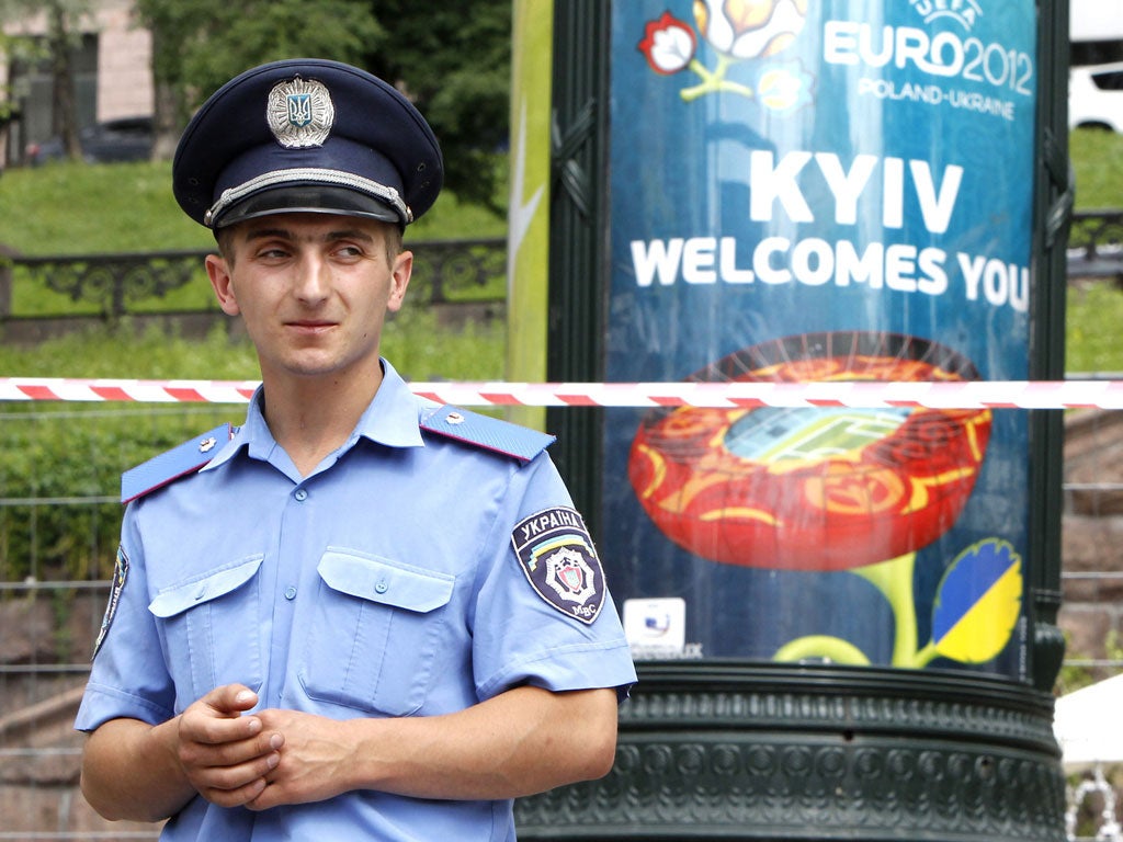 A policeman stands in front of a Euro 2012 poster during a bomb alert in Kiev yesterday – it turned out to be a false alarm