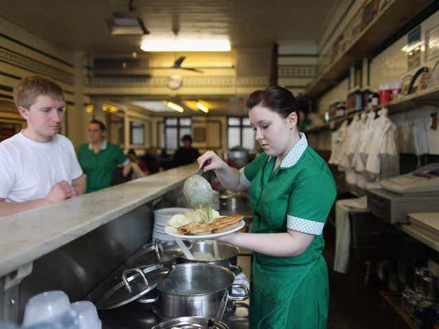 A waitress serves a plate of pie and mash in M.Manze, the oldest trading eel and pie house in London