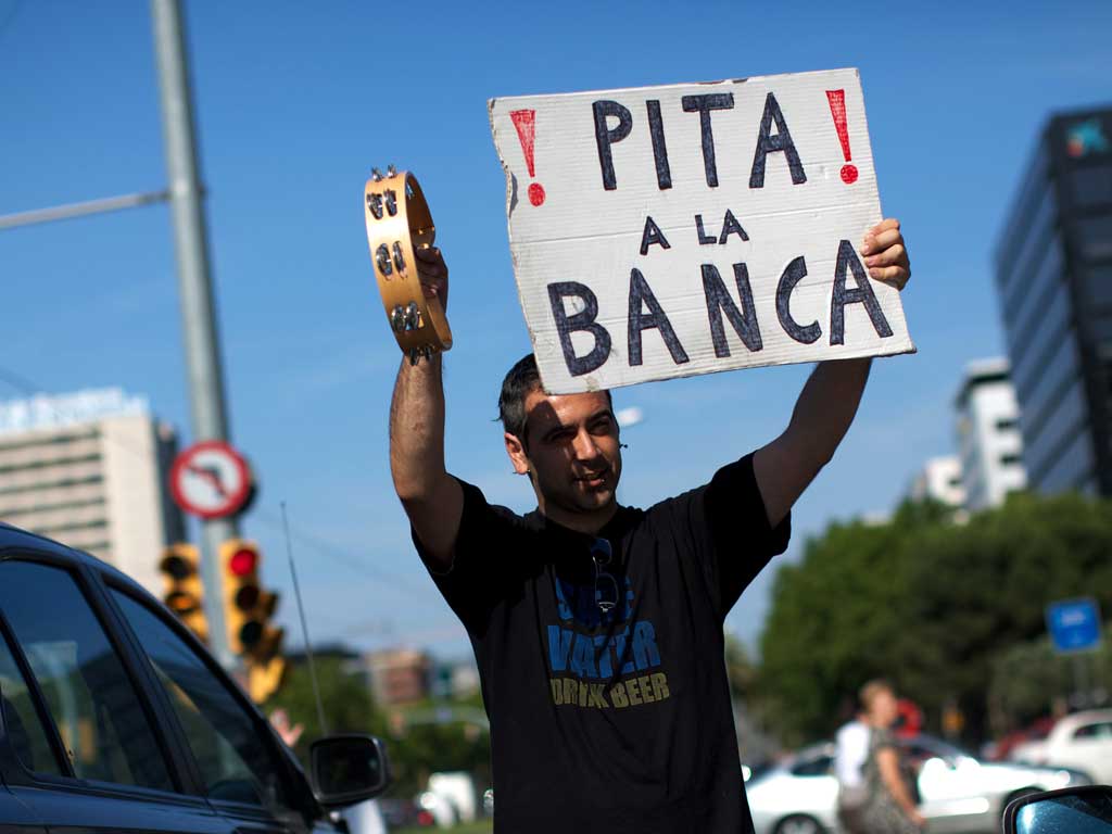 'Honk at the bank' says a placard in Barcelona