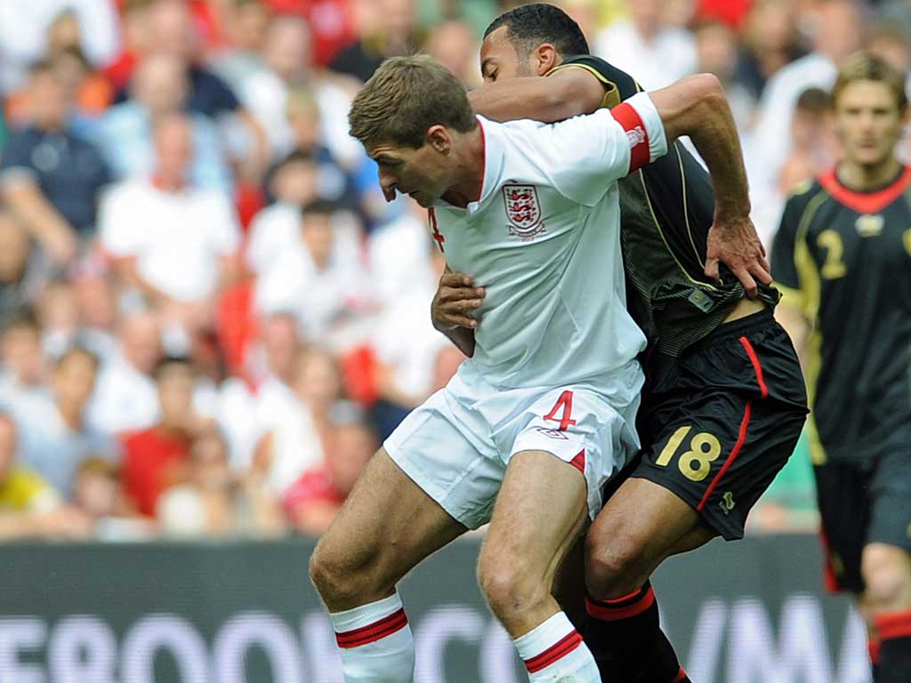 Helping out: Steven Gerrard works to keep possession against Belgium