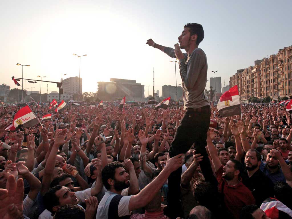 Thousands of protesters gather in Cairo yesterday to wave national flags and chant anti-military slogans