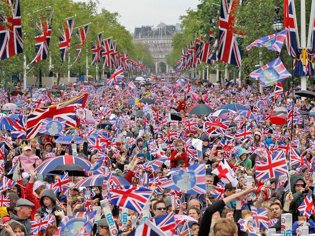 Revelers crowd the Mall to watch The Queen appear on the Buckingham Palace balcony