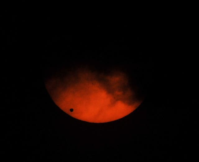 Venus (L) viewed as a small black dot, passes across the sun as seen from a weather observatory in Manila on June 6, 2012. Sky-gazers around the world held up their telescopes and viewing glasses June 6, to watch Venus slide across the sun -- a rare celestial phenomenon that will not happen again for more than 100 years. Other small dots on the right of the photo are called sun spots.
