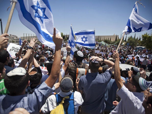 Jewish settlers wave flags during a protest against the proposed decision to evacuate a West Bank outpost in the Ulpana neighbourhood, in the West Bank settlement of Beit El
