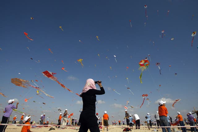 Palestinian children fly kites in the town of Beit Lahiya