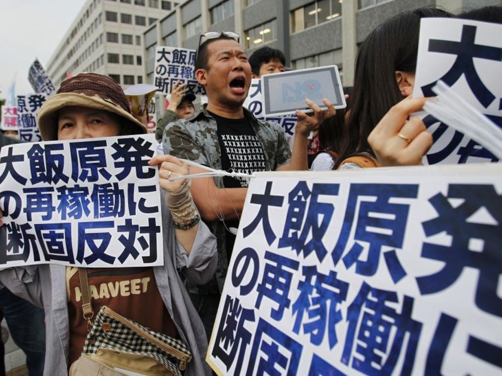 Protesters against the restart of nuclear power plants, shout slogans in front of the Japanese