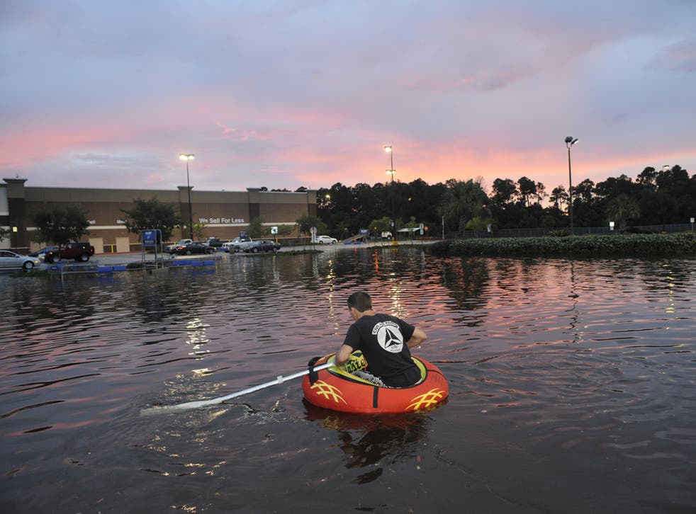 A teenager paddles his way through a flooded car park after heavy rain and rising water levels battered the state of Florida in June 2012