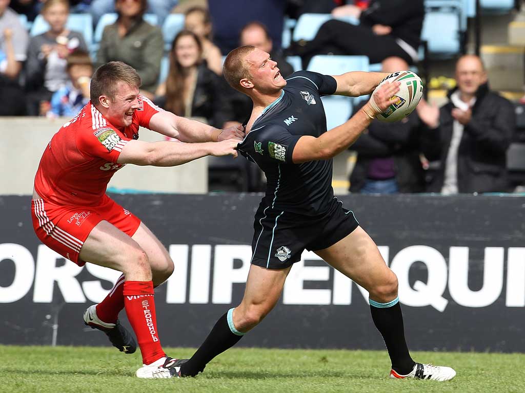 Pulling power: Paddy Flynn of Widnes tries to pull back London's Jamie O'Callaghan in yesterday's 28-24 Broncos win