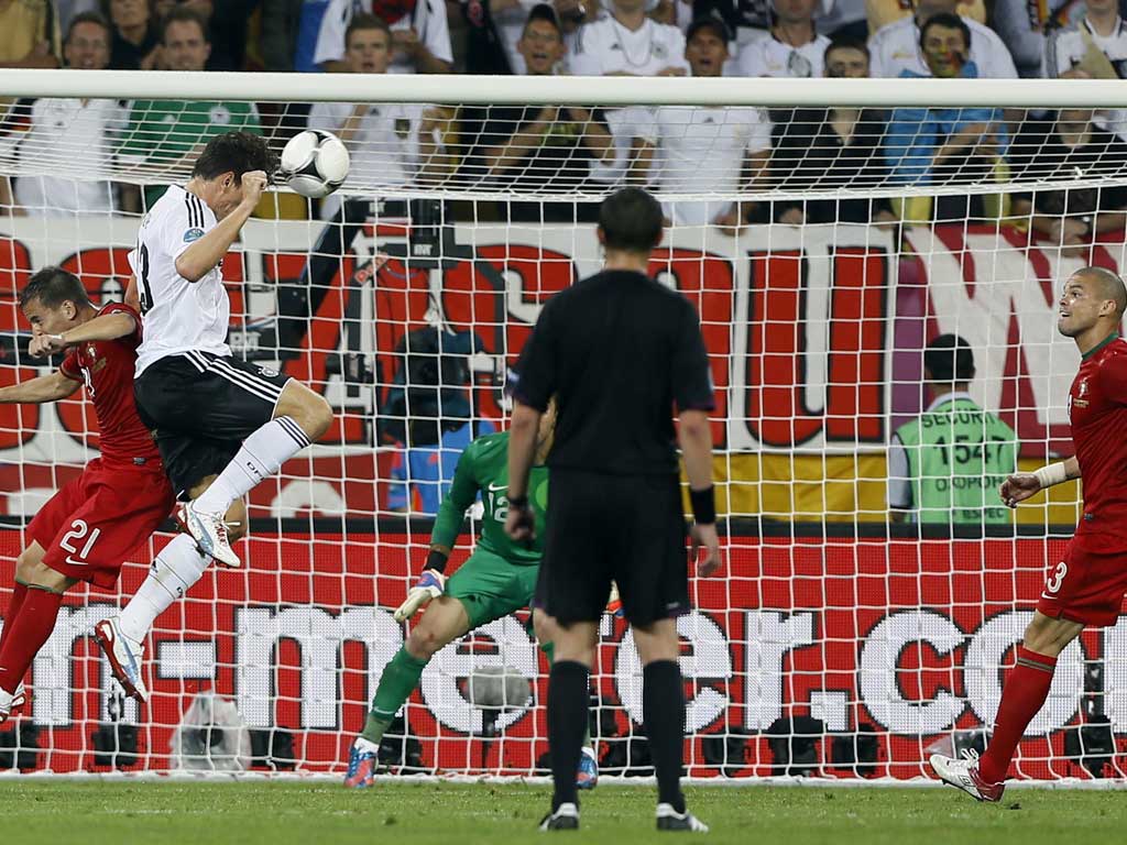 Germany's Mario Gomez, second left, heads the ball into the goal during the Euro 2012 game against Portugal