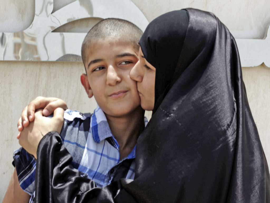 Khadija Habib kisses her son, Ali Hasan, who was released from a police station near the capital, Manama, yesterday after a month in jail