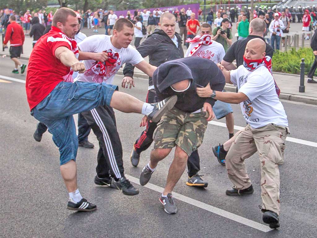 Polish and Russian fans clash outside the stadium in Warsaw before the match