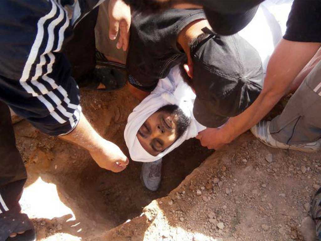 Syrians bury a victim of violence in Homs province on Sunday