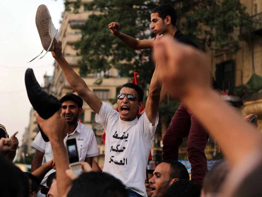 Egyptian anti-military protesters wave their shoes as they protest in Cairo's Tahrir Square against Mubarak-era prime minister and presidential candidate Ahmed Shafiq after Egypt's top court rejected a law barring him from standing in a tense presidential
