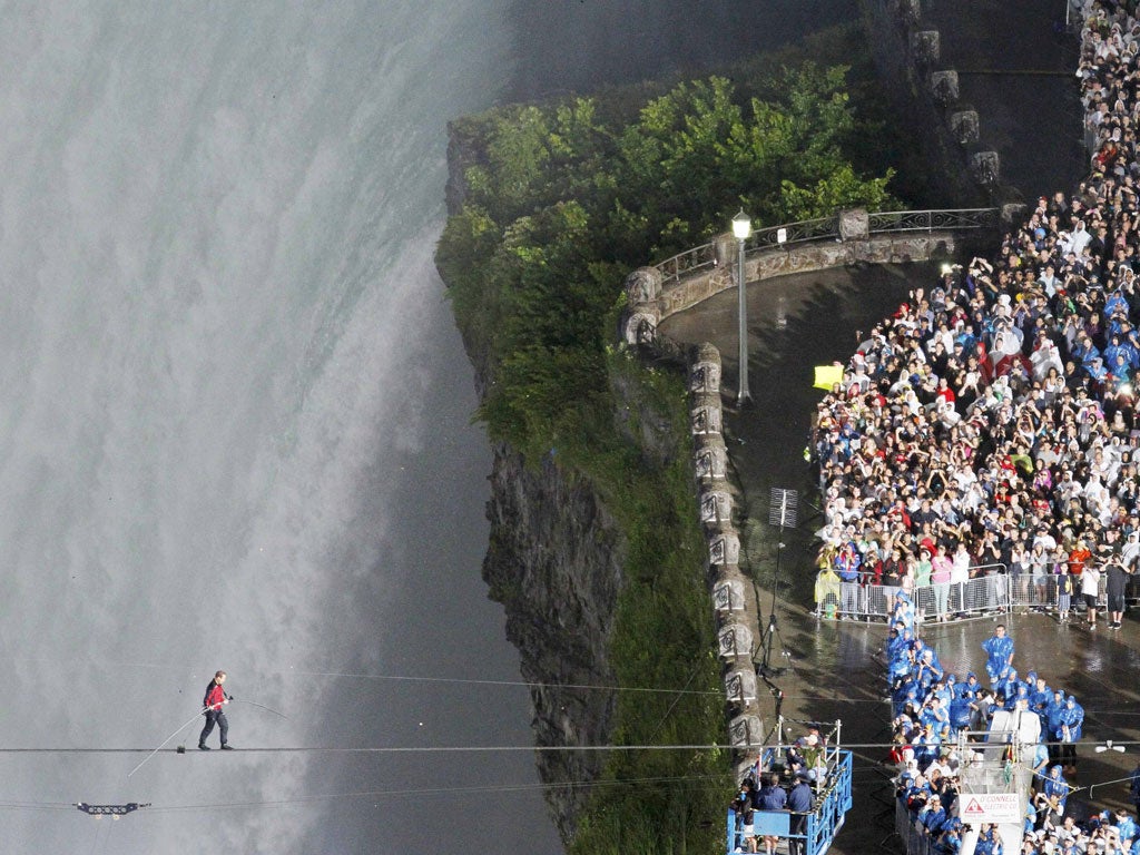 Nik Wallenda nears the Canadian side of Niagara Falls by tightrope, attracting 100,000 spectators