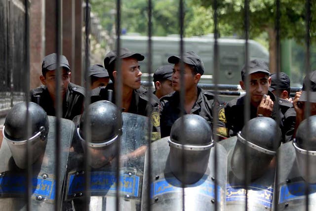 Egyptian riot police stand outside the parliament as protesters gather in Cairo