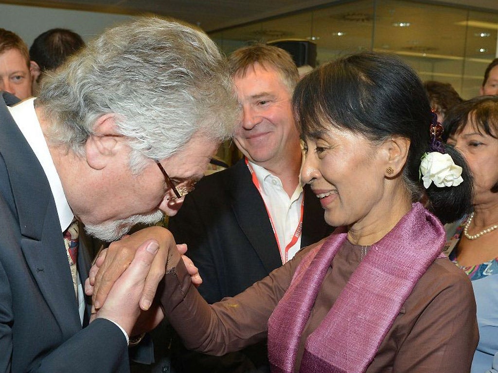 Former BBC World Service presenter Dave Lee Travis kisses the hand of Aung San Suu Kyi during her visit to BBC Broadcasting House in central London