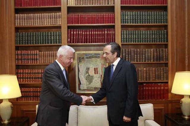 Newly appointed Greek prime minister Antonis Samaras (right) shakes hands with outgoing caretaker prime minister Panagiotis Pikrammenos