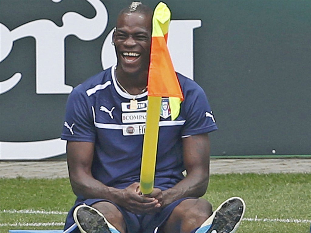 Mario Balotelli has fun with a corner flag during a break from training in Krakow