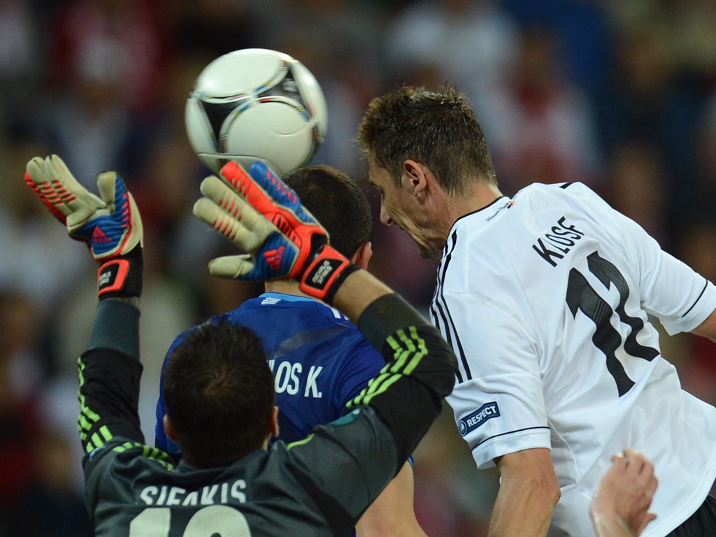 Miroslav Klose (R) scores during the Euro 2012 football championships quarter-final match Germany vs Greece