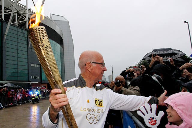 Fans came in their drones to support football legend Bobby Charlton as he carried the Olympic flame through Manchester