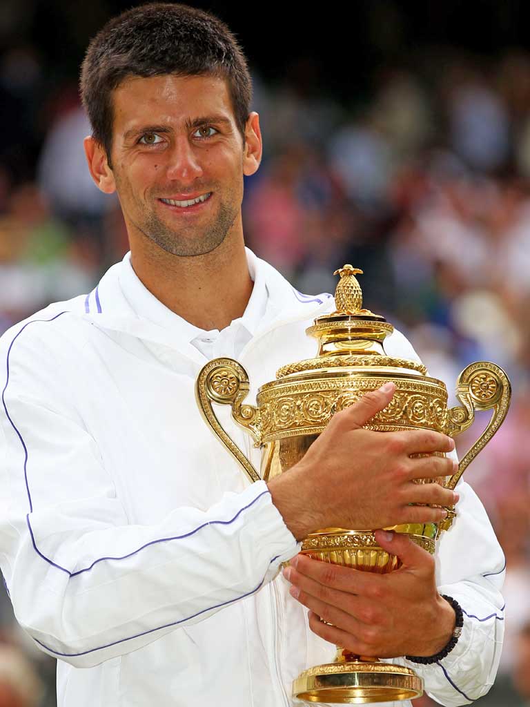 Novak Djokovic at Wimbledon last year with the trophy he is about to defend