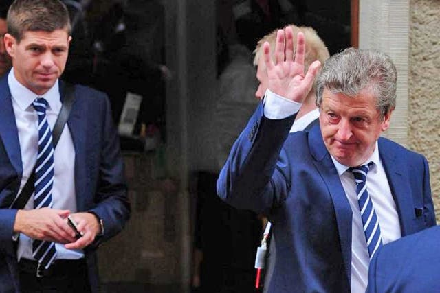 Roy Hodgson, with Steven Gerrard behind him, waves as England leave Poland