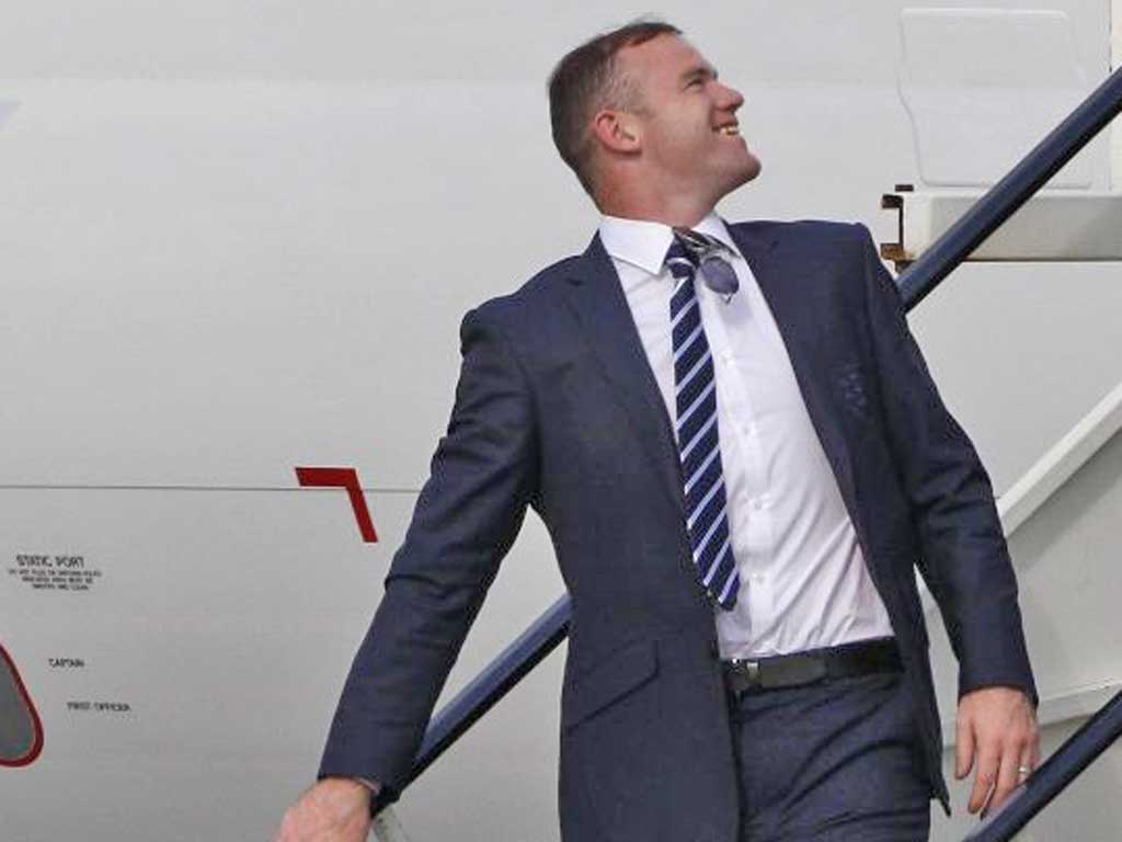 Wayne Rooney is all smiles on his return to England after his team’s exit from Euro 2012