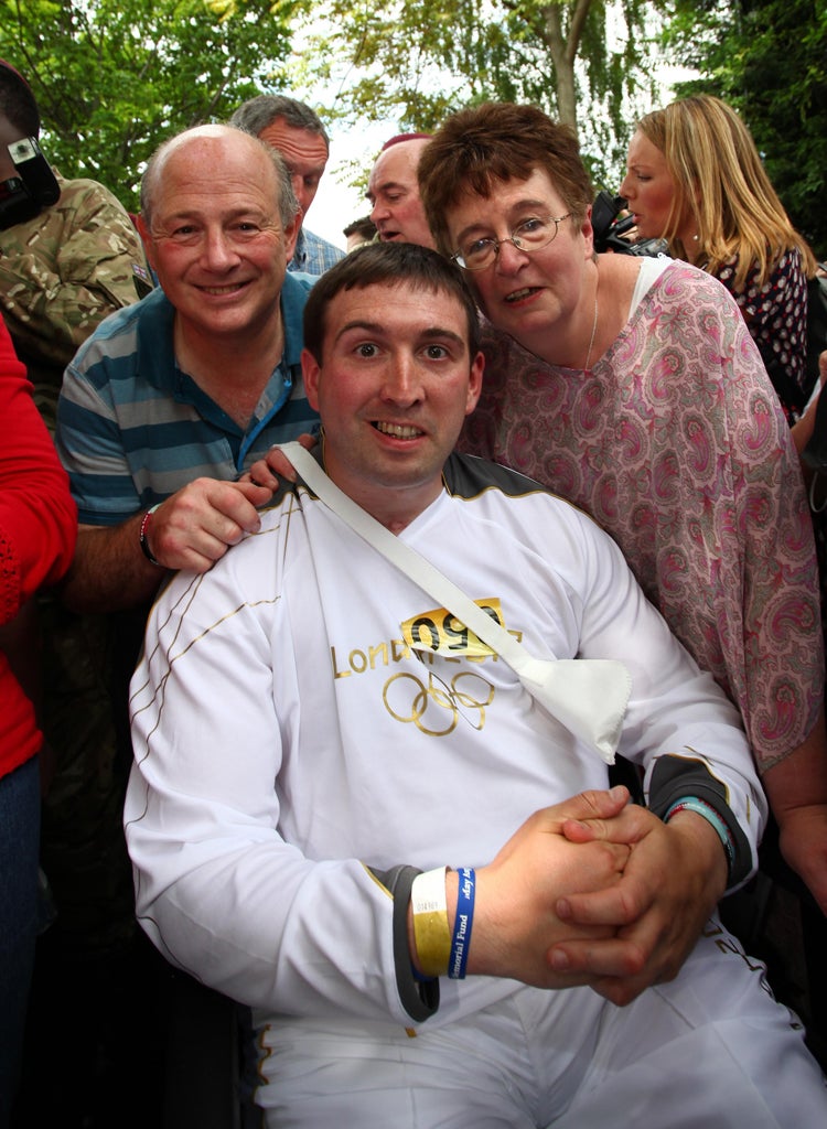 Paratrooper, Lance Bombardier Ben Parkinson, 27, the most seriously wounded soldier to survive the war in Afghanistan, with his step father Andy and mother Diane Dernie, after he carried the Olympic Flame through his home town of Doncaster during  Day 39 of the London 2012 Olympic Torch Relay.