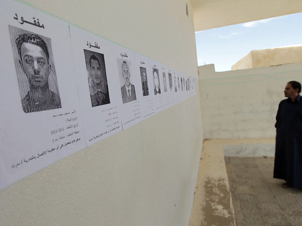Disappeared:
Pictures of
people who went
missing under
Gaddafi are
pasted to a wall
in Sirte
